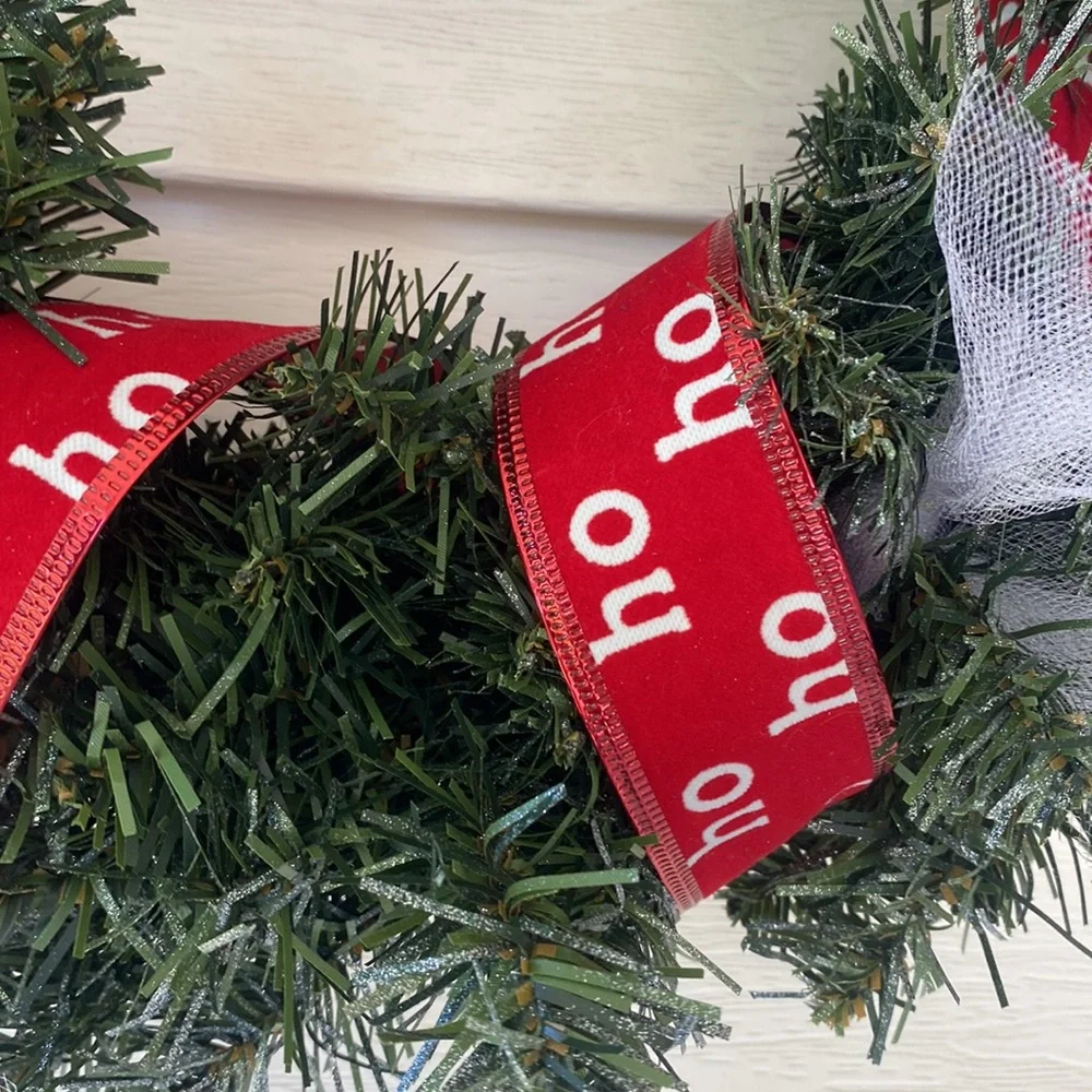 Believe evergreen faux wreath trimmed with the word believe and ho ho ho ribbon